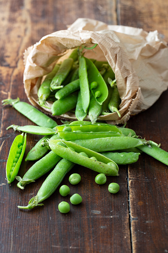 close-up of fresh green peas wearing in paper bag