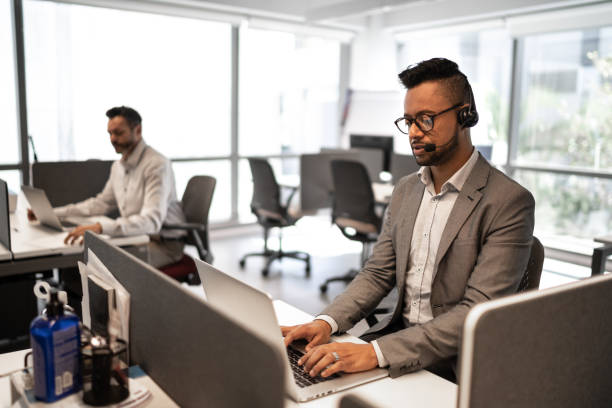 istock Employee working with headset in office callcenter 1264277892