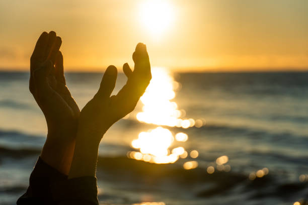 istock woman hands praying for blessing from god during sunrise background. Hope concept. 1264278845