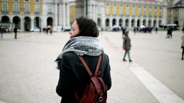 Tourist girl wearing overcoat, backpack and scarf