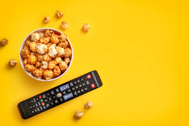 istock Popcorn in cardboard box and tv remote control 1264280395