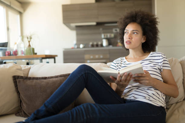istock Afro american female relaxing at home reading a book 1264281836