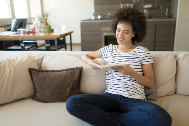 istock Afro american female relaxing at home reading a book 1264281865