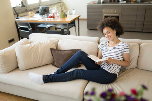istock Afro american female relaxing at home reading a book 1264281867
