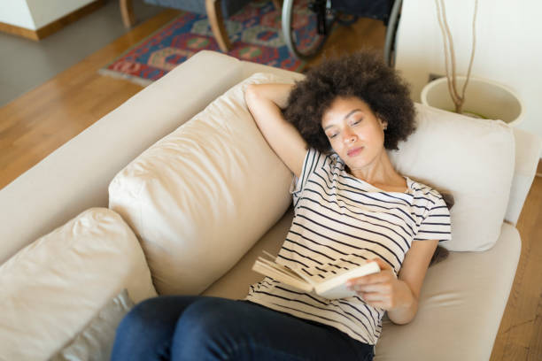 istock Afro american female relaxing at home reading a book 1264281873