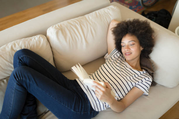 istock Afro american female relaxing at home reading a book 1264281885
