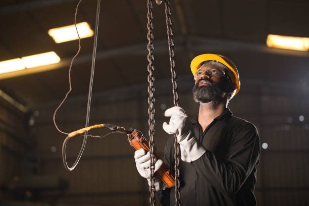istock Worker operating chain hoist at factory 1264282293