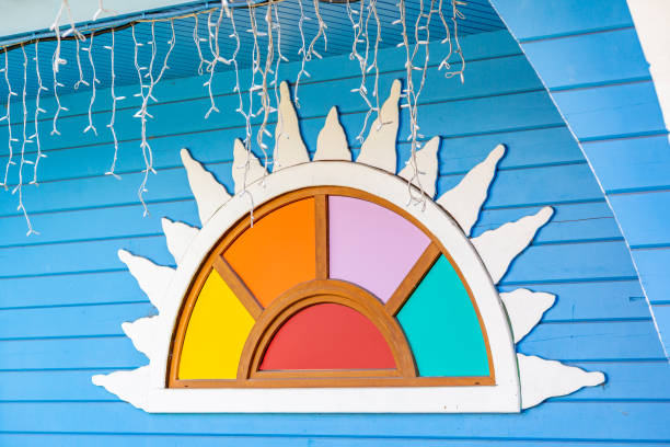 The idea of decorating a multicolored window opening in a wooden wall of a village house