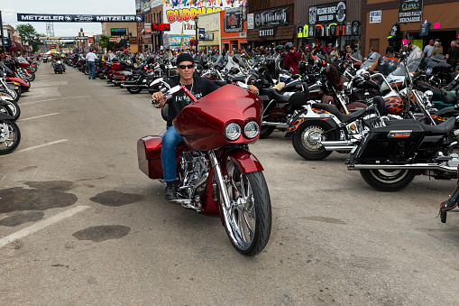 Sturgis, South Dakota - August 8, 2014: A byker riding his chopper motorcycle during the annual Sturgis Motorcycle rally in the main street of the city of Sturgis.