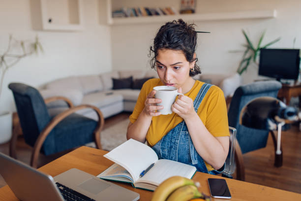 istock Young woman working at home and drinking coffee 1264290528