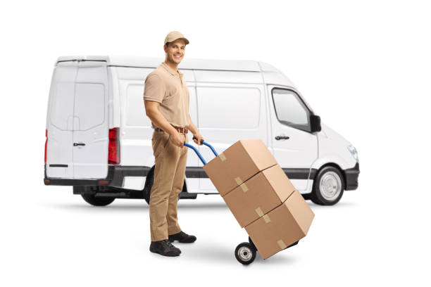 Man delivering boxes and standing in front of a white van Man delivering boxes and standing in front of a white van isolated on white background mover delivery person box hand truck stock pictures, royalty-free photos & images