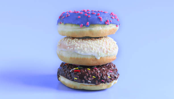 istock Three delicious doughnuts of different colors are arranged in a pyramid on a blue background. Holidays sweets, baking for children, sugar concept 1264292844