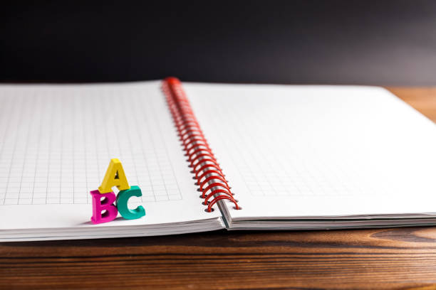 istock English ABC alphabet letters on notebook with black background 1264295414