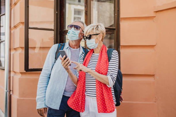 pareja mayor en una escapada a la ciudad usando máscara protectora para la cara - mental illness energy people men fotografías e imágenes de stock