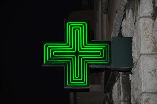 Closeup of a green pharmacy sign outside a pharmacy store
