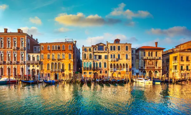 Photo of Venice, Grand Canal, gondolas and buildings at sunrise. Italy