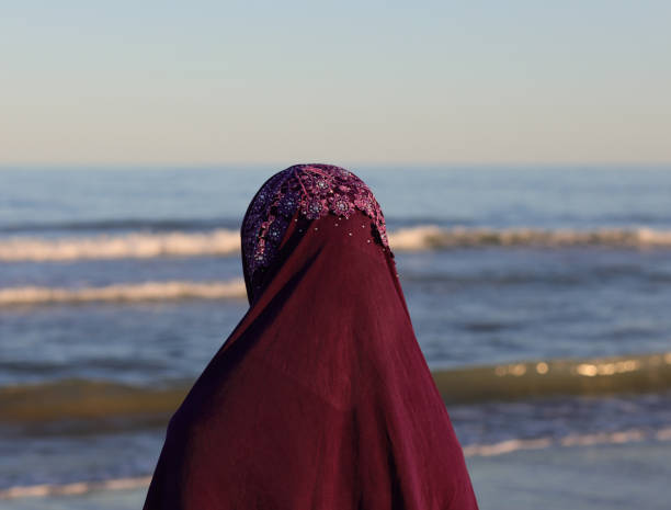 istock young arab with veil on her head by the sea in summer 1264301998
