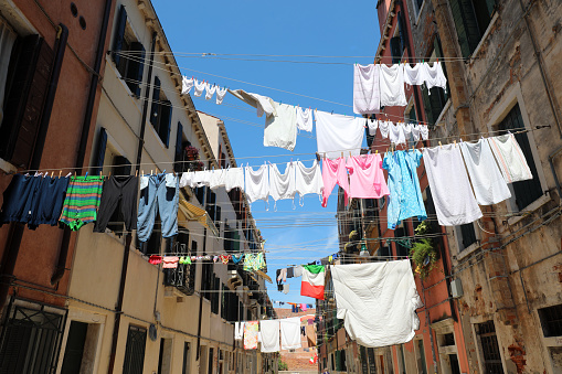 clean clothes hanging out to dry in the sun and an Italian flag in Italy