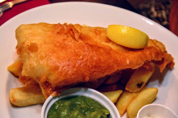 istock TEMPURA BEER BATTERED HADDOCK
SERVED WITH CHIPS, TARTAR SAUCE, LEMON WEDGE WITH MUSHY PEAS 1264306509