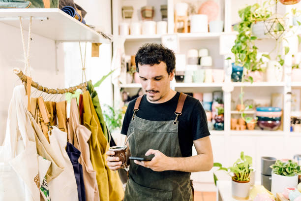 istock Small Business Owner taking a break- drinking mate and using smart phone 1264306706
