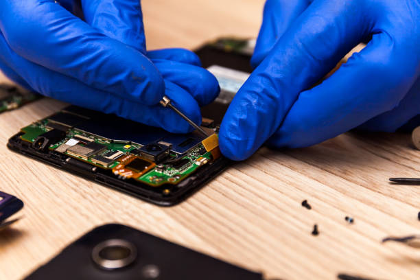 istock Technician repairing mobile phone at table, closeup 1264308135