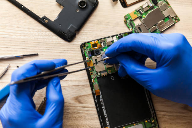 istock Technician repairing mobile phone at table, closeup 1264308153