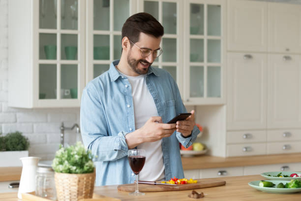 istock Young man read recipe on cell cooking in kitchen alone 1264315275
