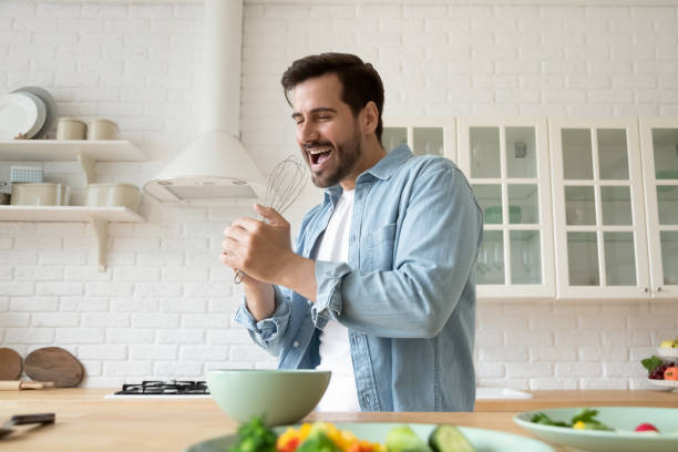 istock Overjoyed young man have fun preparing food in kitchen 1264315296