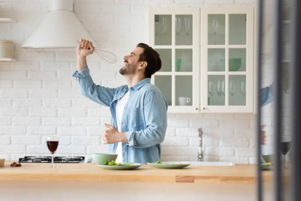 istock Overjoyed young man have fun cooking in kitchen 1264315304