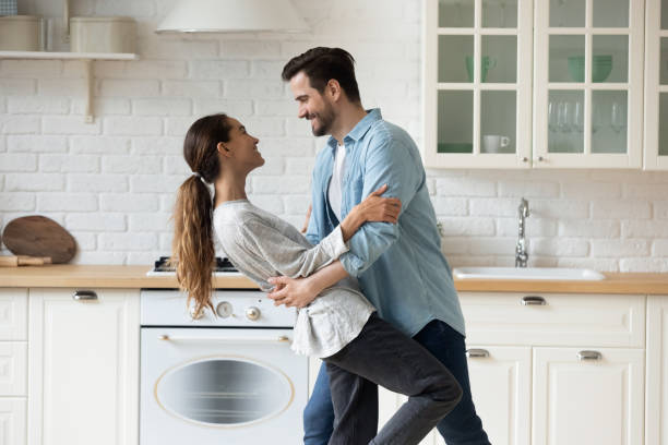 istock Happy couple have fun dancing in modern kitchen together 1264315320