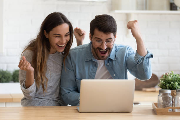 istock Overjoyed young couple triumph winning lottery online 1264315833