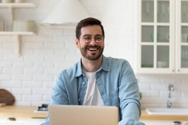 istock Happy young man work at laptop talking with friend 1264315847