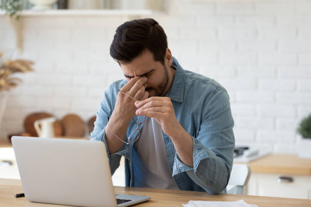 istock Exhausted young man take off glasses suffer from headache 1264315852
