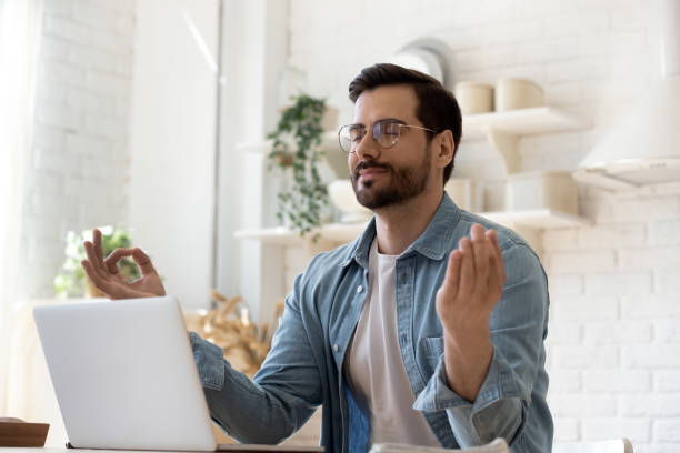 istock Calm young man meditate at home workplace 1264315855