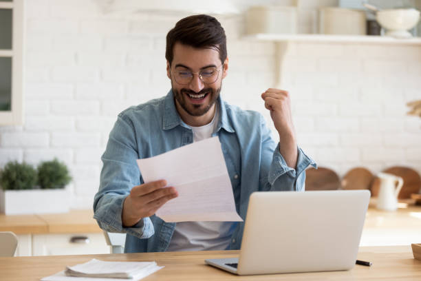istock Overjoyed young man feel euphoric reading good news in letter 1264315856