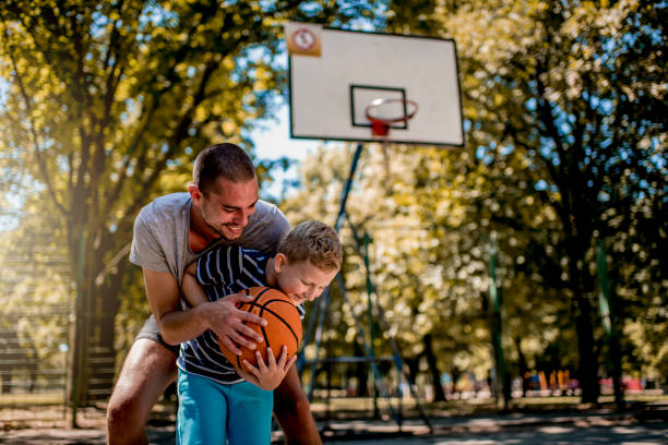 istock Cute blond boy practicing basketball with his coach 1264316634