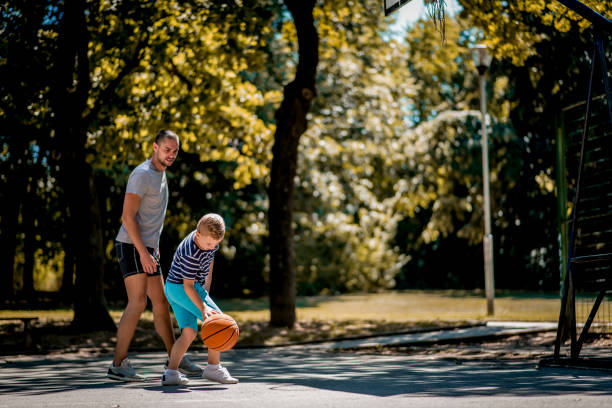 istock Cute blond boy practicing basketball with his coach 1264317215