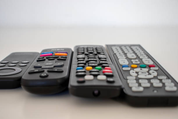 os controles remotos, um para cada dispositivo usado. - entertainment home interior electronics industry remote control - fotografias e filmes do acervo