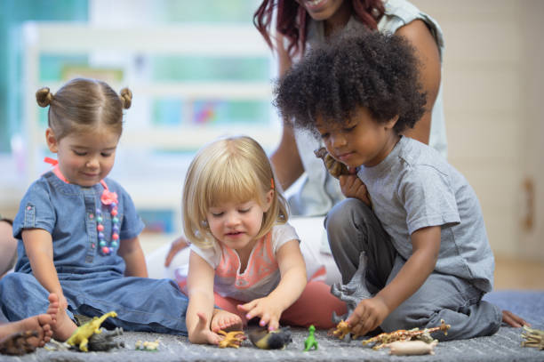 istock Daycare teacher builds blocks with toddlers 1264323511