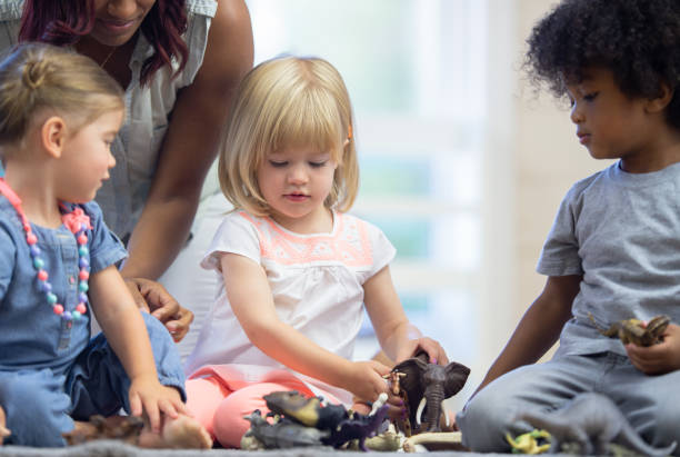 istock Daycare teacher builds blocks with toddlers 1264323527