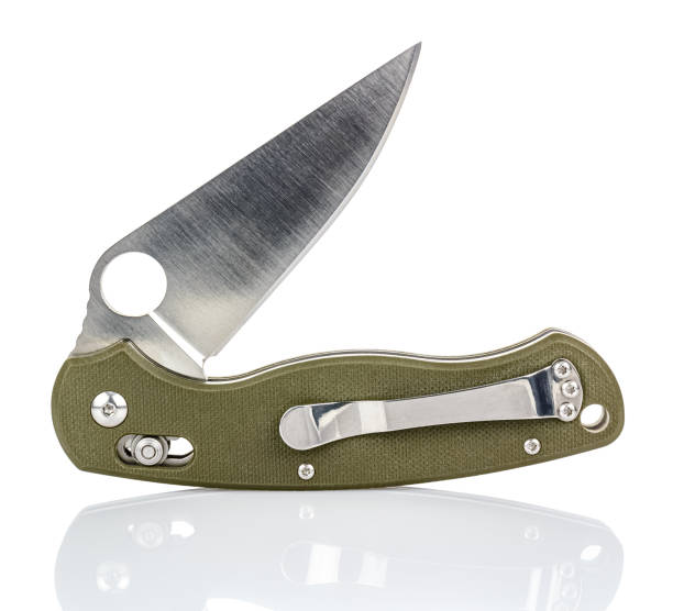 istock Open folding pocket knife with matte blade and textured dark green composite plastic cover plates on steel handle isolated on white background with reflection on glossy surface. Pocket knife close-up 1264324575