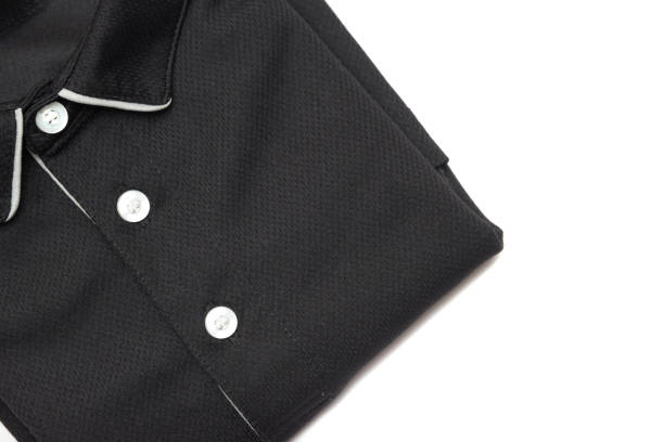 Folded blank black polo shirt with three white buttons. stock photo