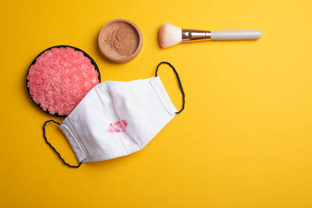 Cosmetics supplies, facemask kiss marked flat lay on yellow stock photo