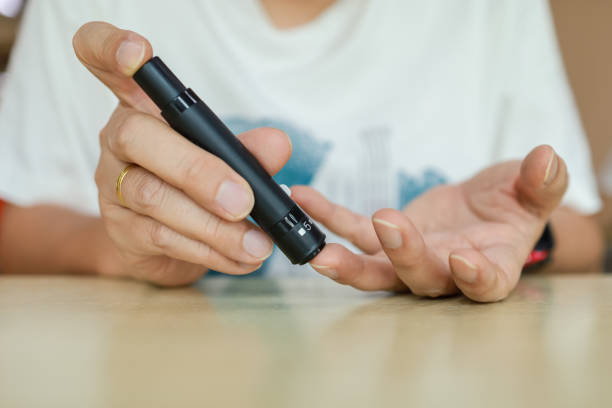 istock Close up of man hands using lancet on finger to check blood sugar level by Glucose meter. Use as Medicine, diabetes, glycemia, health care and people concept. 1264327111