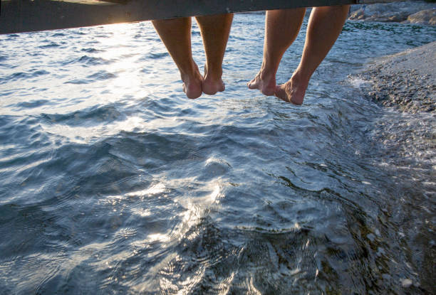 istock View past couple's feet over Mediterranean Sea at sunrise 1264327422