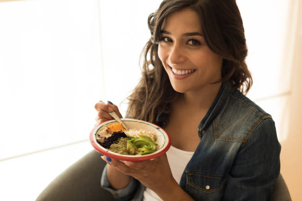 istock Woman eating a vegan bowl 1264327449