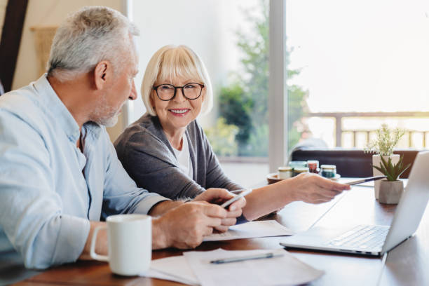istock Senior couple doing home finances using laptop indoors 1264328274