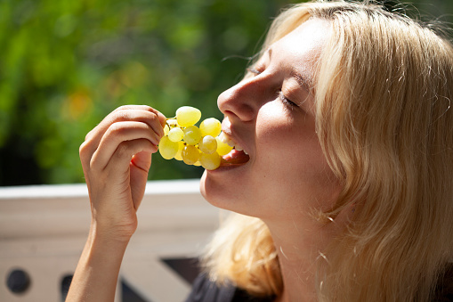 young girl eating grapes