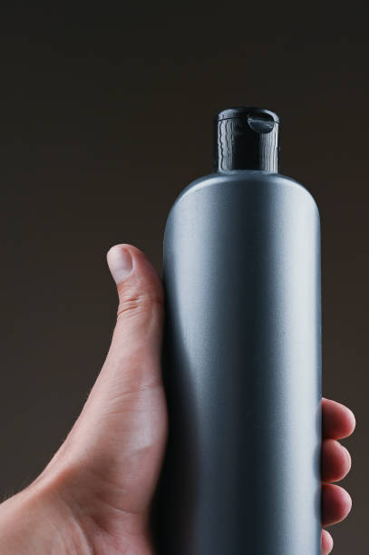 istock mockup of gray plastic bottle in hands on a dark background 1264329061