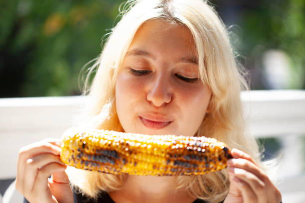 istock young girl eating corn 1264330012